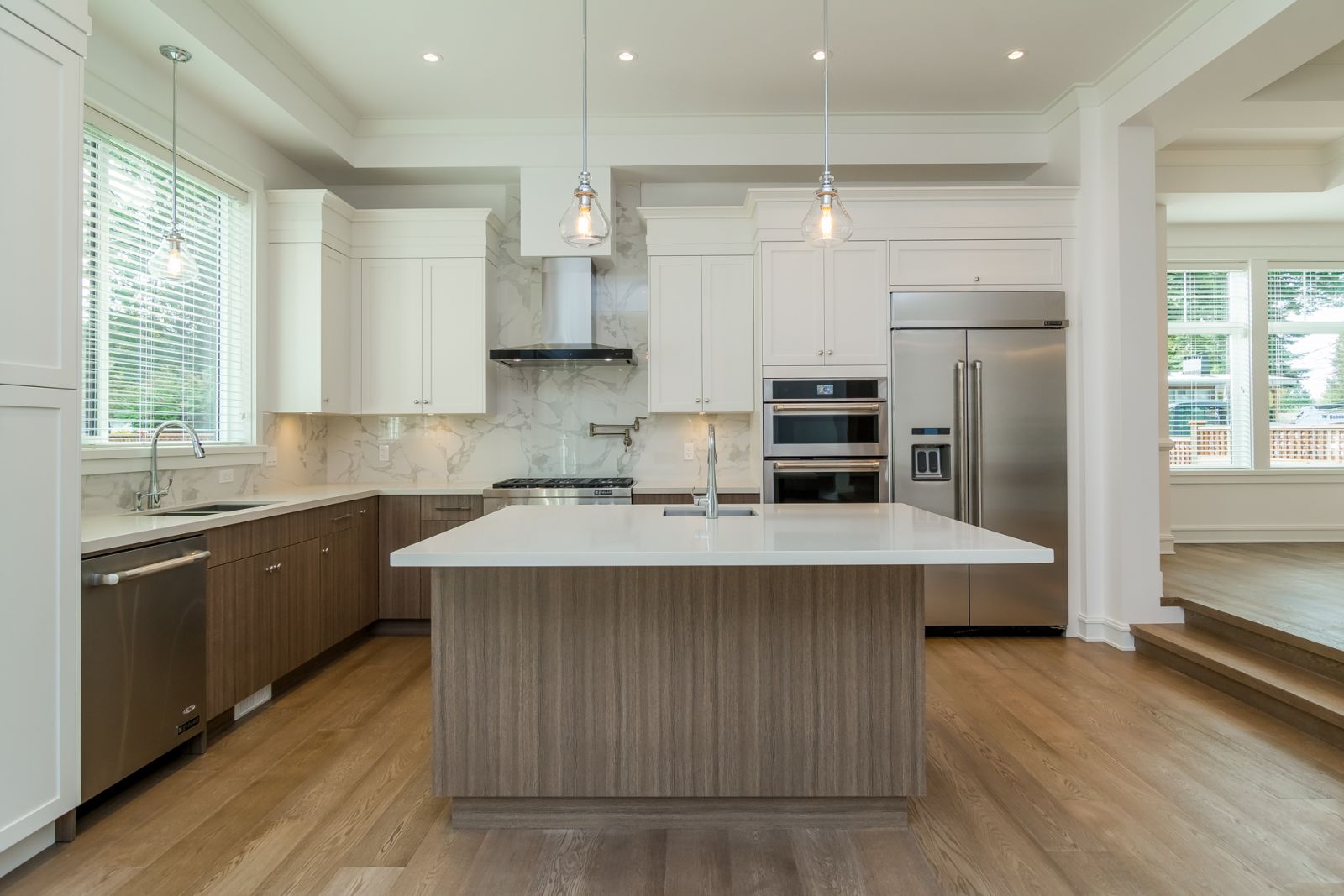 Kitchen Featuring Marble Backsplash and Globe Pendants